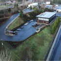 Road leading up to a parking lot and modern warehouse building